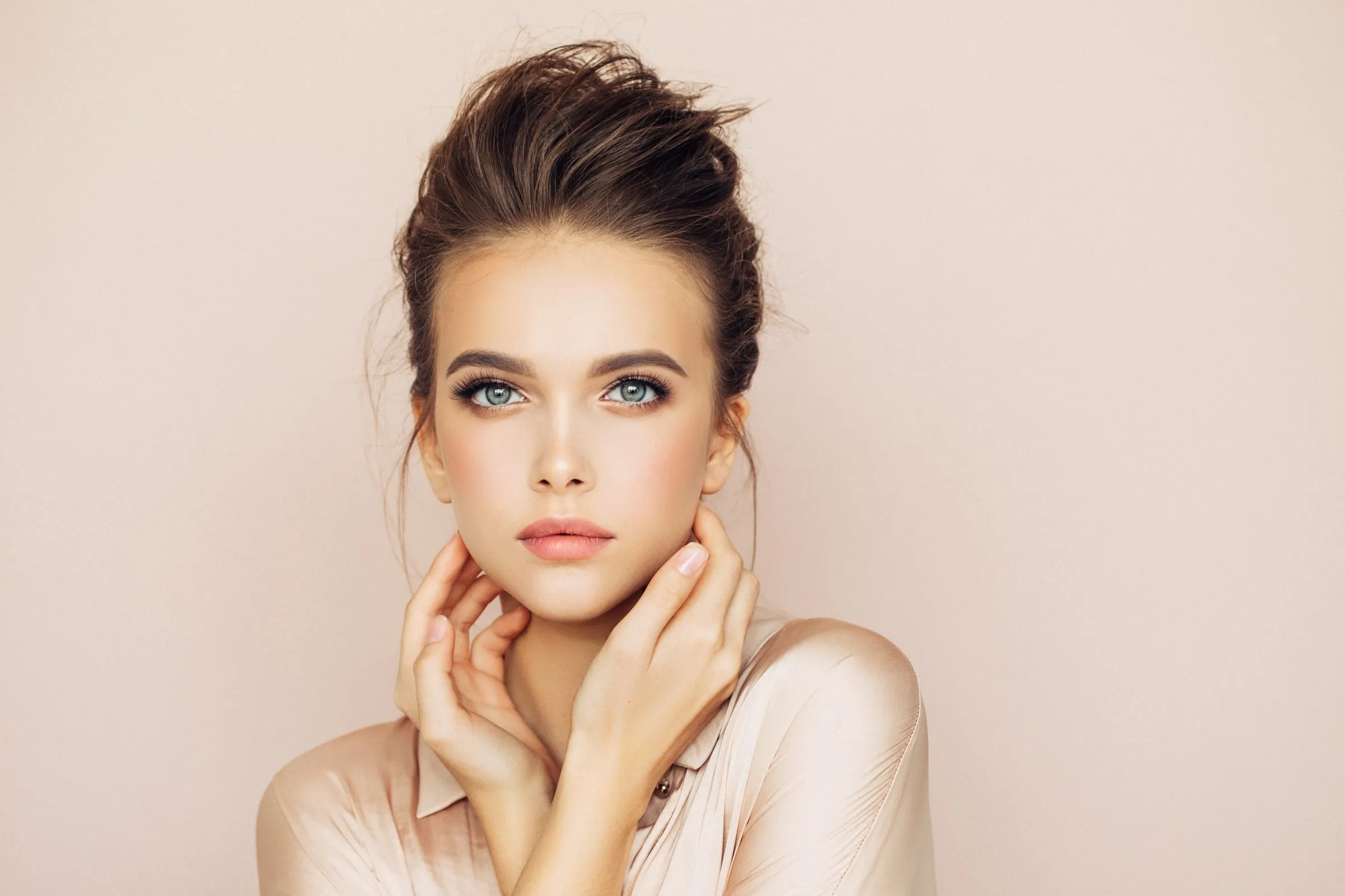 A woman with clear, even skin and her hair pinned up